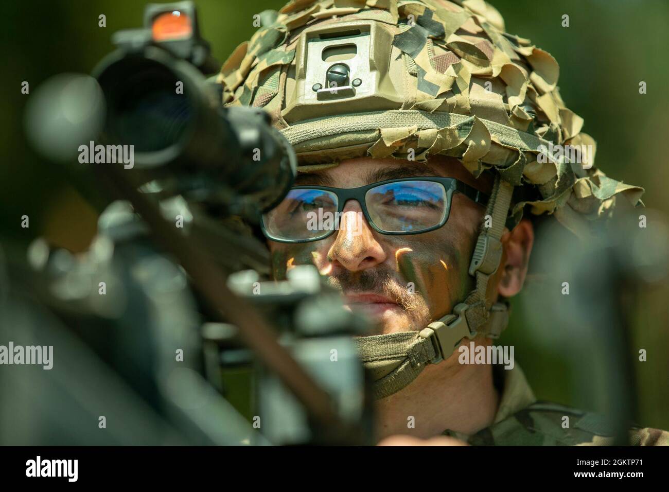 Der britische Soldat Ben Hammond, Royal Anglian Regiment, Poacher-Truppe, steht während der multinationalen Einsatzbereitschaft-Übung „Rifle Ready“ im Bemowo Piskie Training Area, Polen, am 1. Juli 2021 unter einem schweren Maschinengewehr unter die Wache und sichert einen Bereich. Rifle Ready war eine multinationale Einsatzbereitschaft-Übung bei der Battle Group Poland. Soldaten aus den USA, Großbritannien, Rumänien und Kroatien testeten die Einsatzbereitschaft und die multinationale Interoperabilität und demonstrierten damit die Abschreckung der NATO. Stockfoto