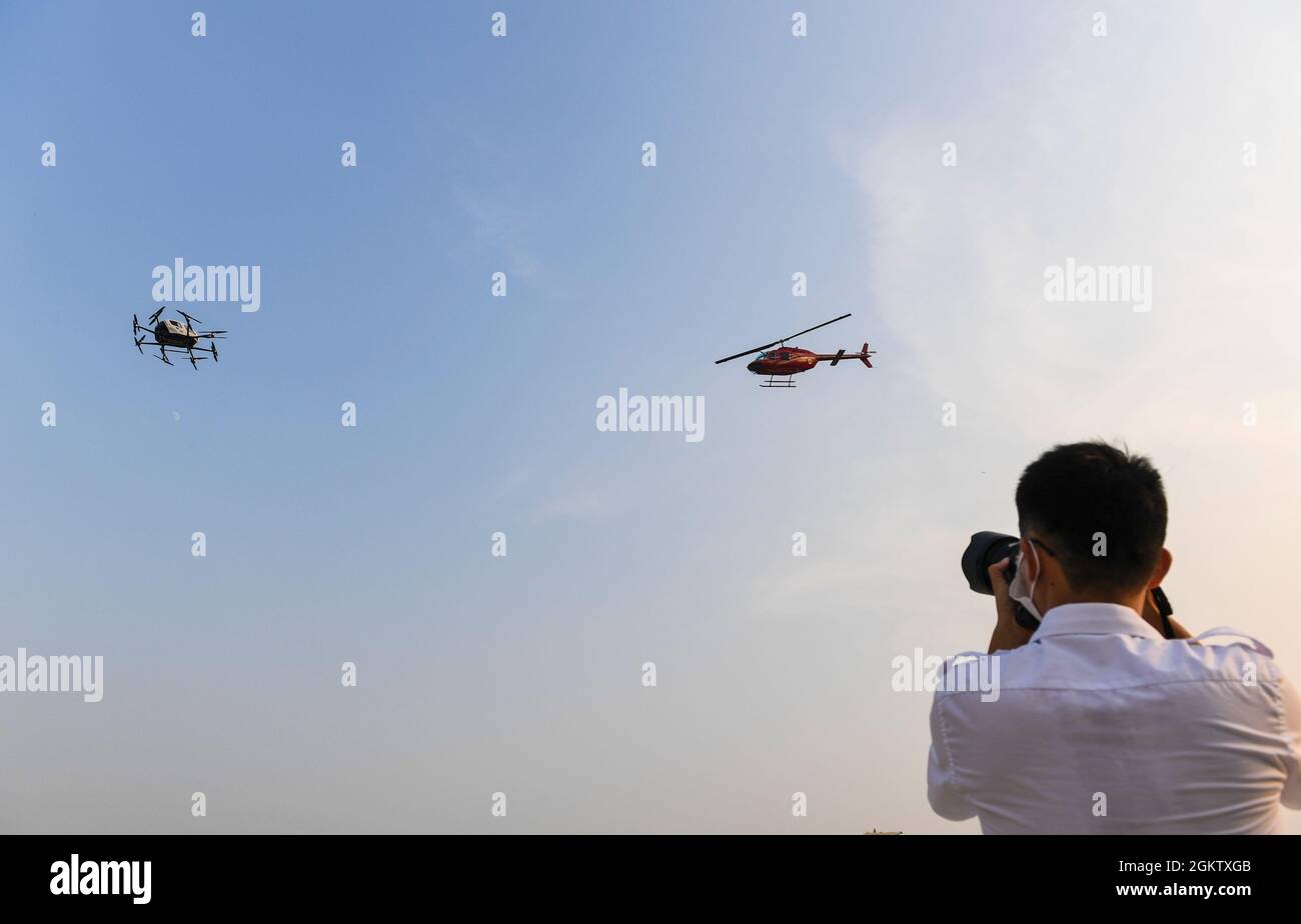 (210916) -- SHENZHEN, 16. September 2021 (Xinhua) -- Ein Bell 206-Hubschrauber (R) von HELI-EASTERN, einem Flugträger für die allgemeine Luftfahrt mit niedriger Flughöhe und Hubschrauberservice, und ein passagiertaugliches autonomes Luftfahrzeug (AAV) von EHANG, einem führenden Anbieter von AAV-Technologieplattformen, nehmen Demoflüge in einem integrierten Luftraum in Shenzhen, der südchinesischen Provinz Guangdong, am 15. September 2021 Teil. Quelle: Xinhua/Alamy Live News Stockfoto