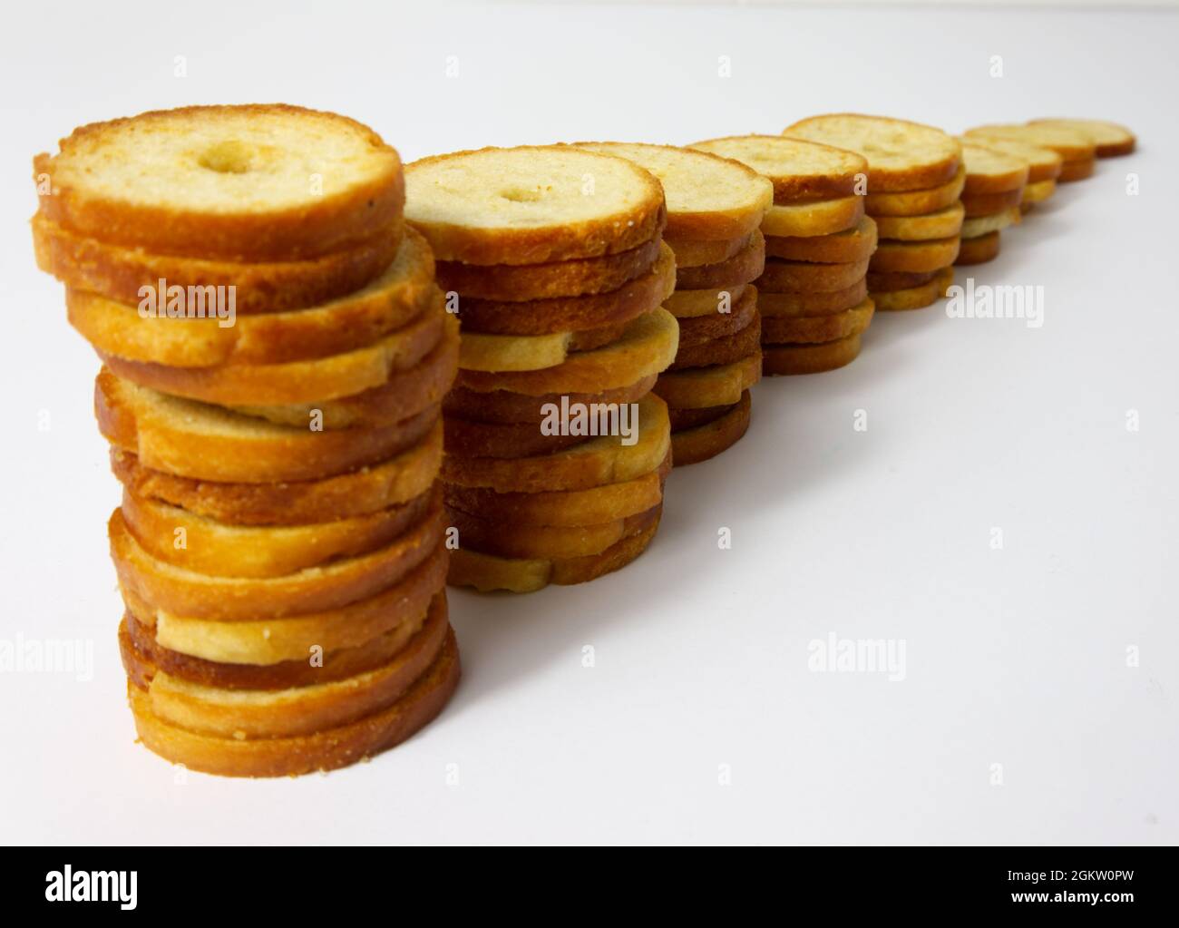 Brötchen backen. Runde gebackene Brotscheiben in einer Reihe angeordnet. Mini-Brotschips aus der Nähe. Stockfoto