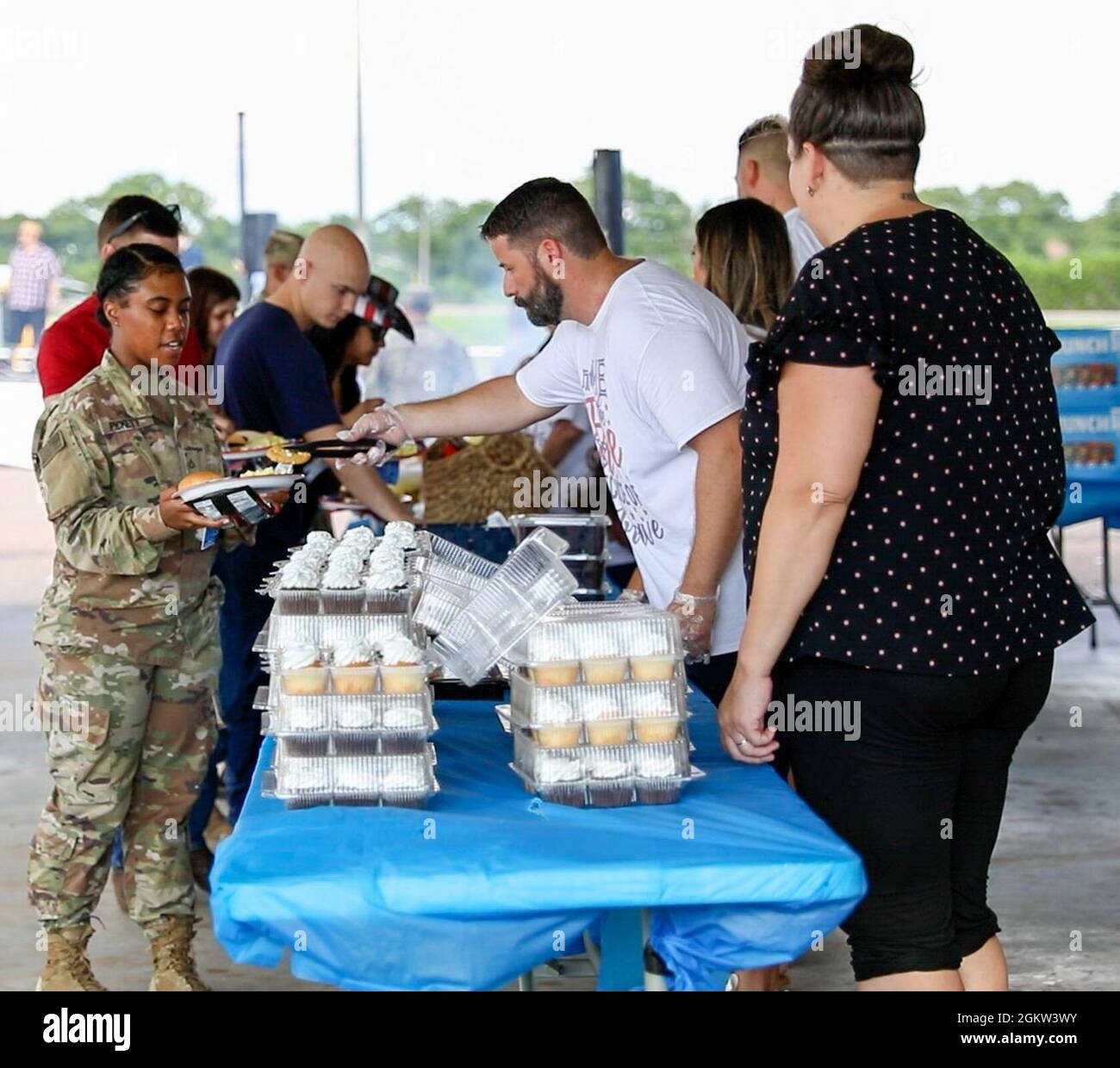 Freiwillige der örtlichen Gemeinde Gatesville bereiten Burger und geräuchertes Schweinefleisch für Soldaten der US-Armee für eine Feier zum Unabhängigkeitstag in Gatesville, Texas, am 4. Juli 2021, zu. Mobilisierende Soldaten aus North Fort Hood wurden zu einer Feier des Unabhängigkeitstages der Gemeinde von Gatesville eingeladen, um vor dem Hauptfeuerwerk Musik zu hören, Spiele zu spielen und zu essen. Stockfoto