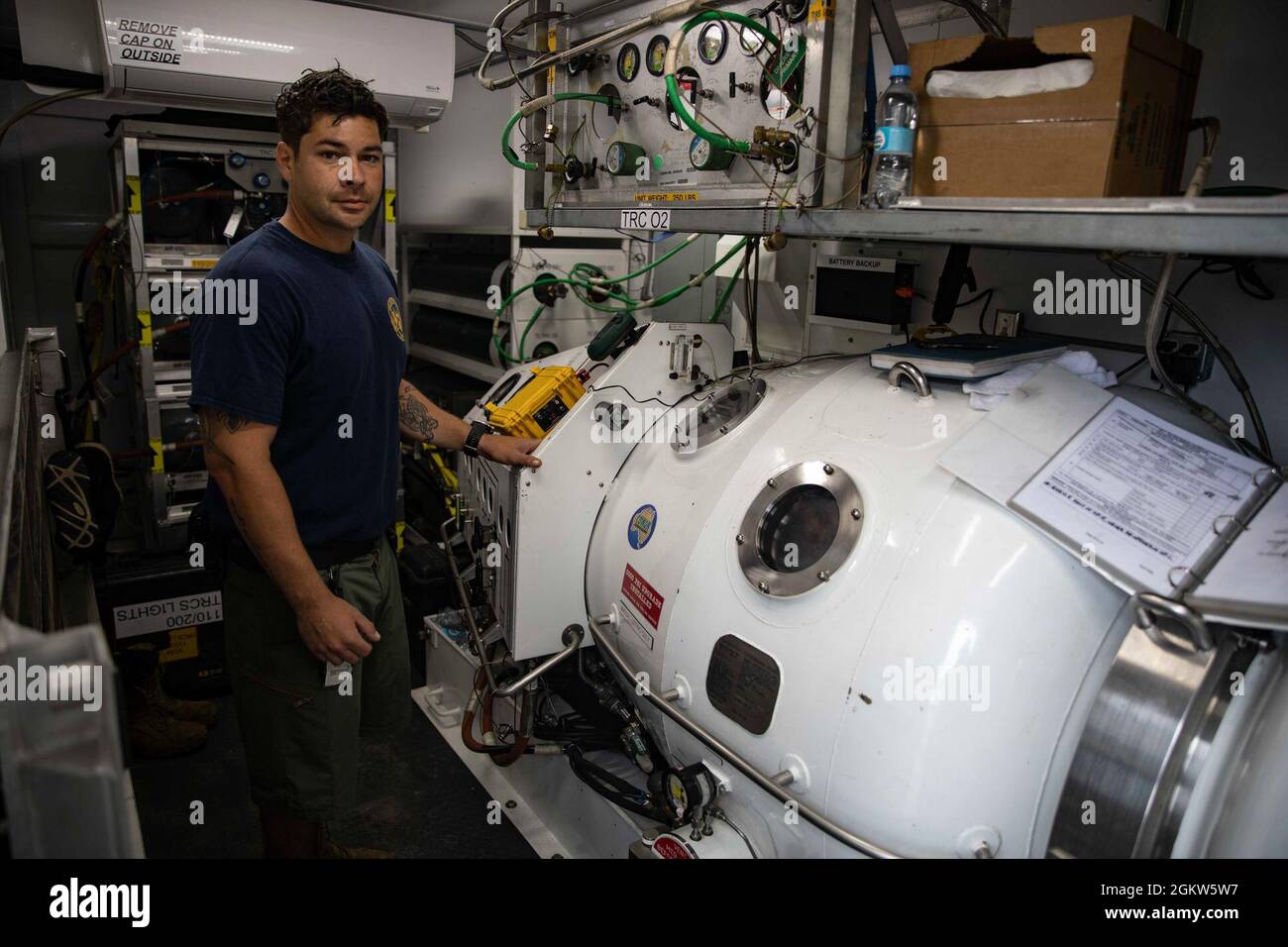 210706-N-BM428-0004 ODESA, Ukraine (6. Juli 2021) Baumechaniker 1. Klasse Ryan Jeffery, Kammerleiter des Unterwasser-Konstruktionsteams 1, posiert während der Übung Sea Breeze 2021 in Odesa, Ukraine, am 6. Juli 2021, für ein Foto neben einer transportablen Rekompressionskammer. Übung Sea Breeze ist eine multinationale maritime Übung, die seit 1997 von der Sechsten Flotte der USA und der ukrainischen Marine veranstaltet wird. Sea Breeze 2021 soll die Interoperabilität der teilnehmenden Nationen verbessern und die Sicherheit und den Frieden im Seeverkehr in der Region stärken. Stockfoto