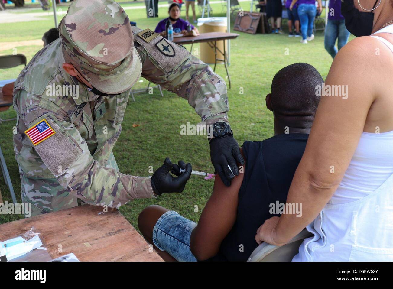1. LT. Carlos Velázquez, ein Sanitäter der Puerto Rico State Guard, verabreicht einem Mann im „Parque Pasivo Las Croabas“ in Fajardo, Puerto Rico, einen Impfstoff gegen COVID-19, 4. Juli 2021. Um die maximale Anzahl von Personen zu erreichen, die gegen COVID-19 geimpft wurden, werden im Rahmen von ​​Operation Warp Speed Streikteams der PRNG verschiedenen Sektoren der Insel zugewiesen. Stockfoto