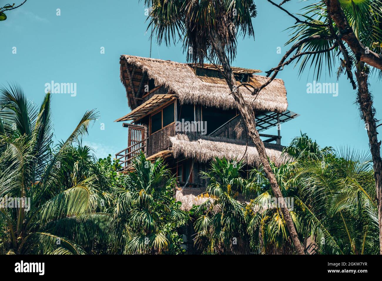 Umweltfreundliches, nachhaltiges Hotel mit Strohdach vor blauem Himmel Stockfoto