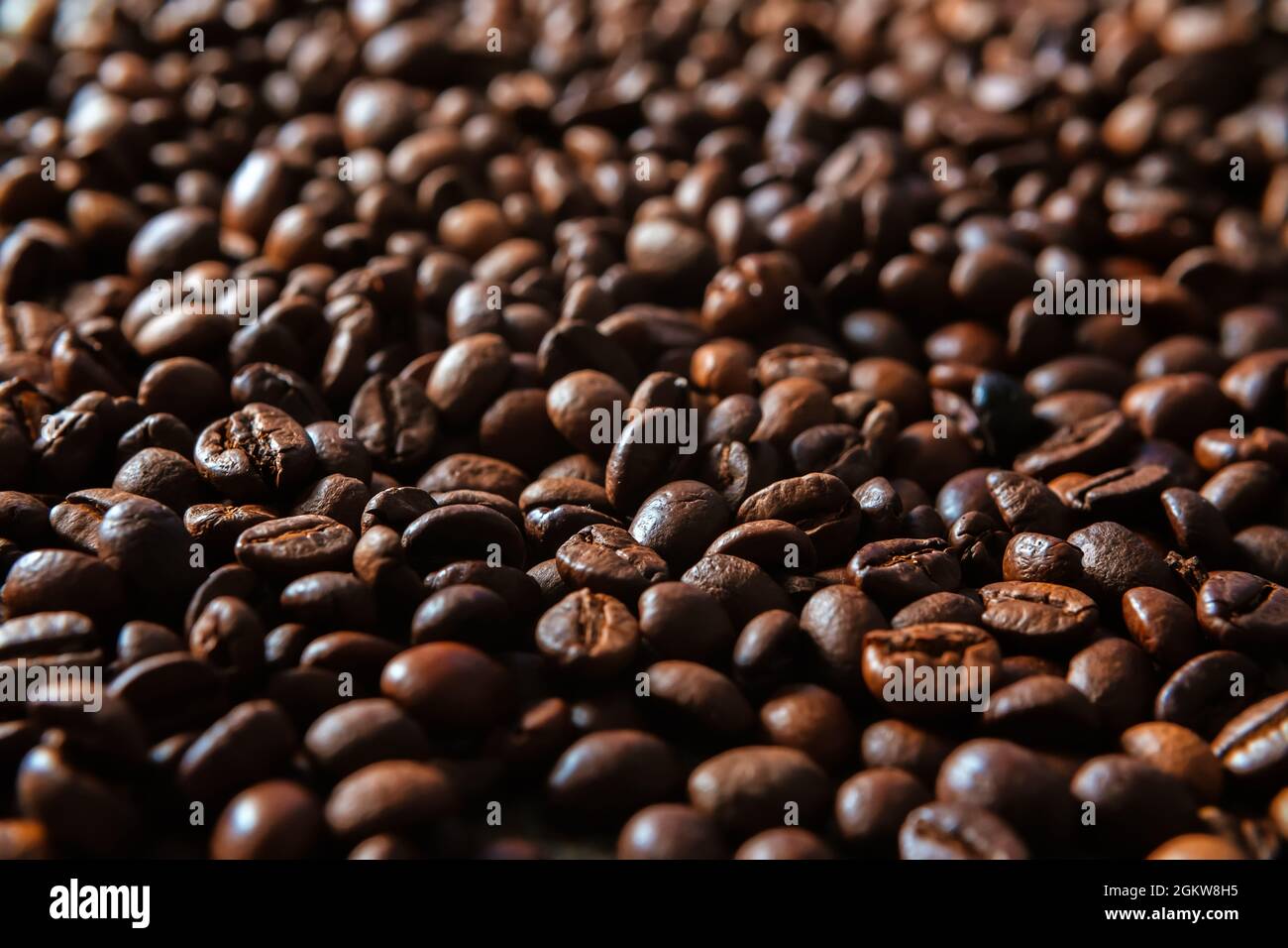 Dunkle geröstete Kaffeebohnen Hintergrund. Großer Stapel gerösteter Espressokerne aus nächster Nähe Stockfoto