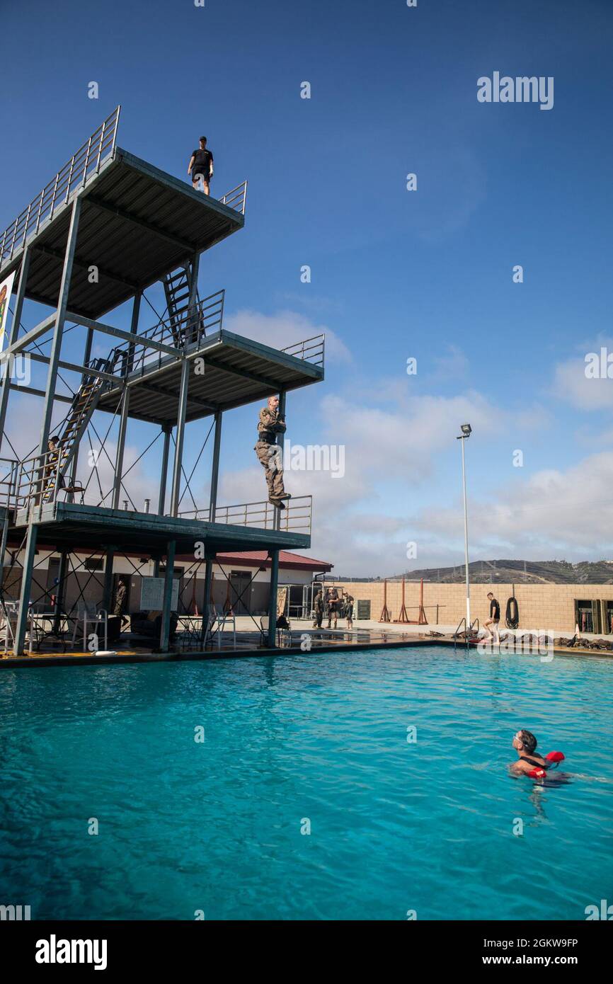 Eine US-Marine mit 1. Bataillon, 5. Marine-Regiment, 1. Marine-Division, springt während einer Schwimmqualifikation im Marine Corps Base Camp Pendleton, Kalifornien, 7. Juli 2021 vom Hochtauchgang ab. Marineinfanteristen müssen sich jährlich neu qualifizieren, um die Einsatzbereitschaft, die Bequemlichkeit im Wasser und die schnelle Reaktionszeit im Falle eines Wasserunfalls zu gewährleisten. Stockfoto