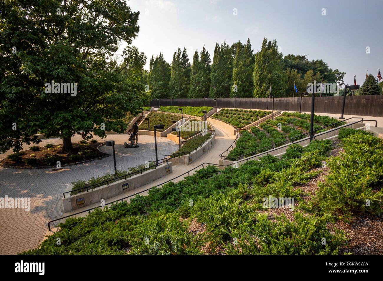 Ansicht des New Jersey Vietnam Veterans’ Memorial in Holmdel, N.J., 7. Juli 2021. In der Mitte befindet sich die Northern Red Oak, der State Tree von New Jersey, sowie drei Bronzestatuen, die diejenigen darstellen, die nach Hause kamen, die Frauen, die dienten und diejenigen, die nicht zurückkamen. Das Memorial, ein kreisförmiger Freiluftpavillon mit einem Durchmesser von 200 Fuß, wurde von Hien Nguyen entworfen, der 1975 aus Vietnam in die Vereinigten Staaten kam. Sie besteht aus 366 8 Fuß hohen schwarzen Granitplatten, die jeweils einen Tag des Jahres repräsentieren. An dem Tag, an dem sie getötet wurden, sind auf den Granitplatten Verletzte aufgeführt. Der Mai Stockfoto