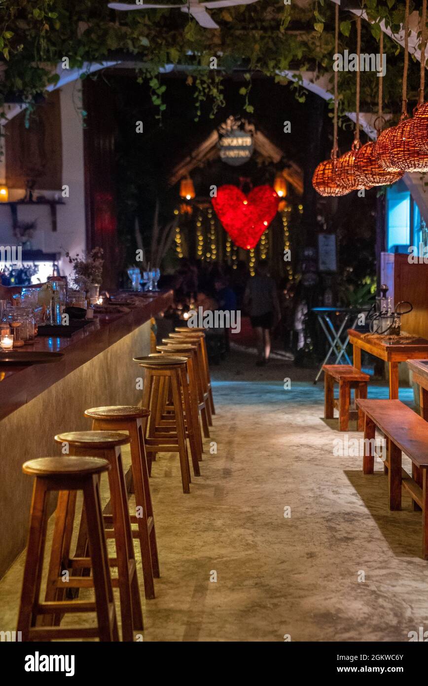 Beleuchtetes Restaurant mit Place Setting und Barschalter am Abend Stockfoto