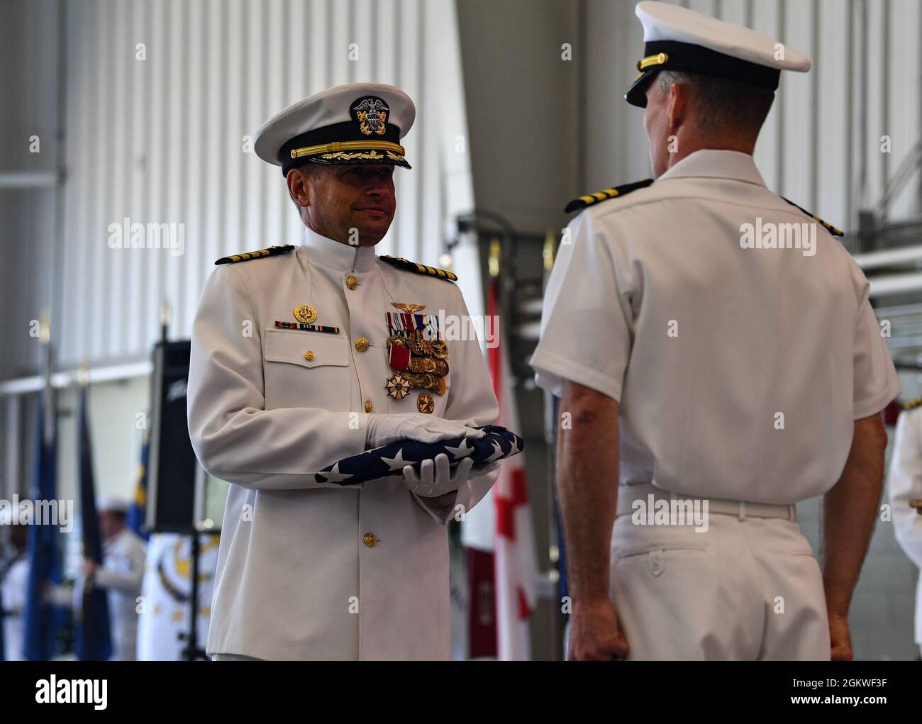 Kapitän Matt Arny, scheidender Kommandant der Naval Air Station Whidbey Island, erhält die Flagge während einer Zeremonie zur Übergabe der Flagge in Oak Harbor, Washington, am 9. Juli 2021. NAS Whidbey Island ist die einzige Unterstützung für die Seeschifffahrt im pazifischen Nordwesten und bietet Einrichtungen, Dienstleistungen und Produkte von höchster Qualität für die Seefluggesellschaft und alle Organisationen, die die Luftverkehrsstation nutzen. Stockfoto