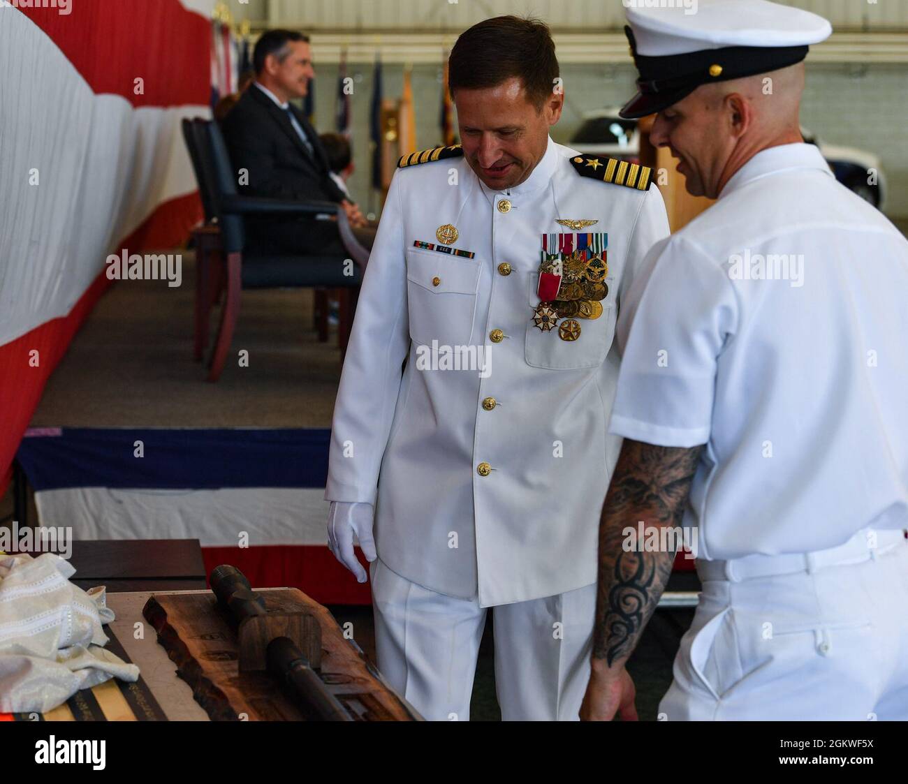 Kapitän Matt Arny, scheidender Kommandant der Naval Air Station Whidbey Island, wird während seiner Ruhestandszeremonie in Oak Harbor, Washington, am 9. Juli 2021 mit einer Schattenbox überreicht. NAS Whidbey Island ist die einzige Unterstützung für die Seeschifffahrt im pazifischen Nordwesten und bietet Einrichtungen, Dienstleistungen und Produkte von höchster Qualität für die Seefluggesellschaft und alle Organisationen, die die Luftverkehrsstation nutzen. Stockfoto