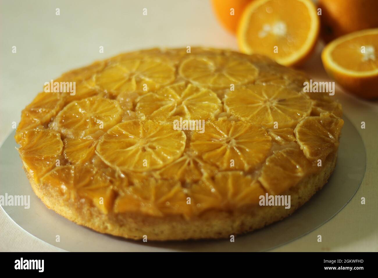 Hausgemachten Orange umgedrehten Kuchen mit Orangenscheiben auf der Oberseite. Aufgenommen auf weißem Hintergrund. Stockfoto