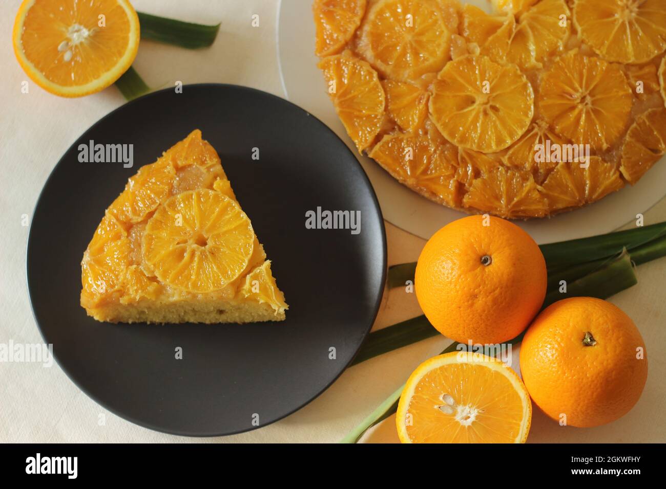 Scheibe selbstgebackenen Orange umgedrehten Kuchen mit orangefarbenen Scheiben auf der Oberseite. Aufgenommen auf weißem Hintergrund. Stockfoto