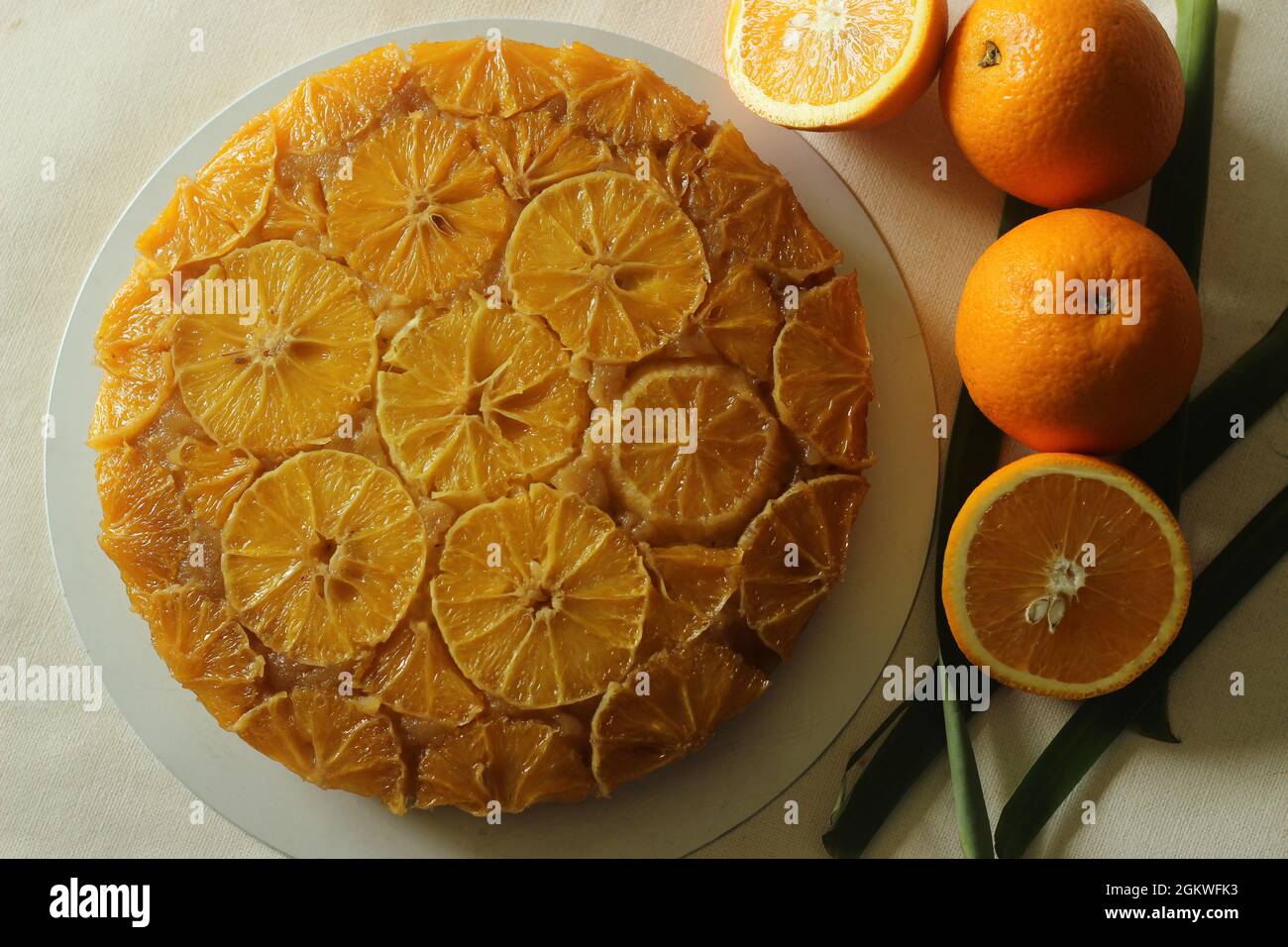 Hausgemachten Orange umgedrehten Kuchen mit Orangenscheiben auf der Oberseite. Aufgenommen auf weißem Hintergrund. Stockfoto