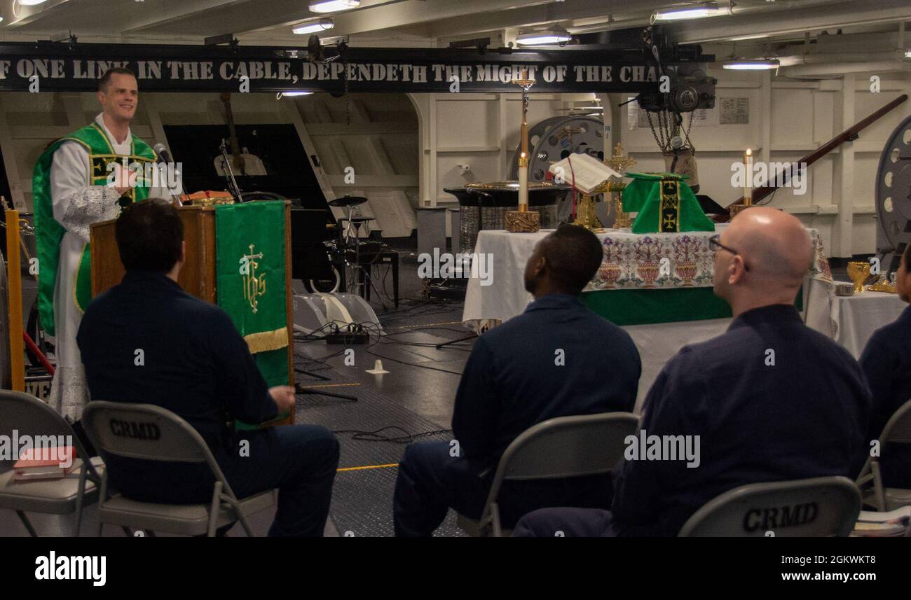 210711-N-RC359-1032 ARABIAN SEA (11. Juli 2021) – Seeleute nehmen am 76. Juli an der katholischen Messe im Vorschiff des Flugzeugträgers USS Ronald Reagan (CVN 11) im Arabischen Meer Teil. Ronald Reagan wird in den Einsatzbereich der 5. US-Flotte eingesetzt, um Marineinteraktionen zu unterstützen, um die maritime Stabilität und Sicherheit in der Zentralregion zu gewährleisten und das Mittelmeer und den Pazifik durch den westlichen Indischen Ozean und drei strategische Engpässe zu verbinden. Stockfoto