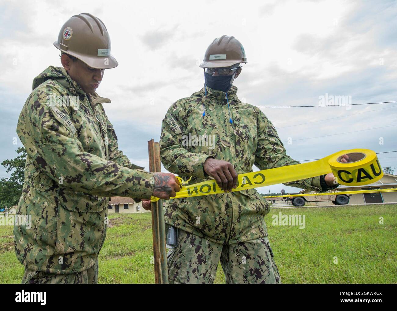 CAMP SHELBY, MISSISSIPPI (12. Juli 2021) der Baustellenmann Ahston Griffin und der Bauelektriker Latavias Rogers, beide dem U.S. Naval Mobile Construction Bataillon (NMCB) 133 zugewiesen, sichern sich bei einer Feldtrainingsübung (FTX) im Camp Shelby, 12. Juli, ein Sicherheitsband auf einem Scheiterhaufen, um einen Bunker zu simulieren. FTX ist eine Trainingsentwicklung, bei der die Seabee-Truppen mehrere missionskribelle Aufgaben planen und ausführen, einschließlich der Sicherheit des Konvois, des Force Protection und des Camp-Setups vor der Bereitstellung. Stockfoto