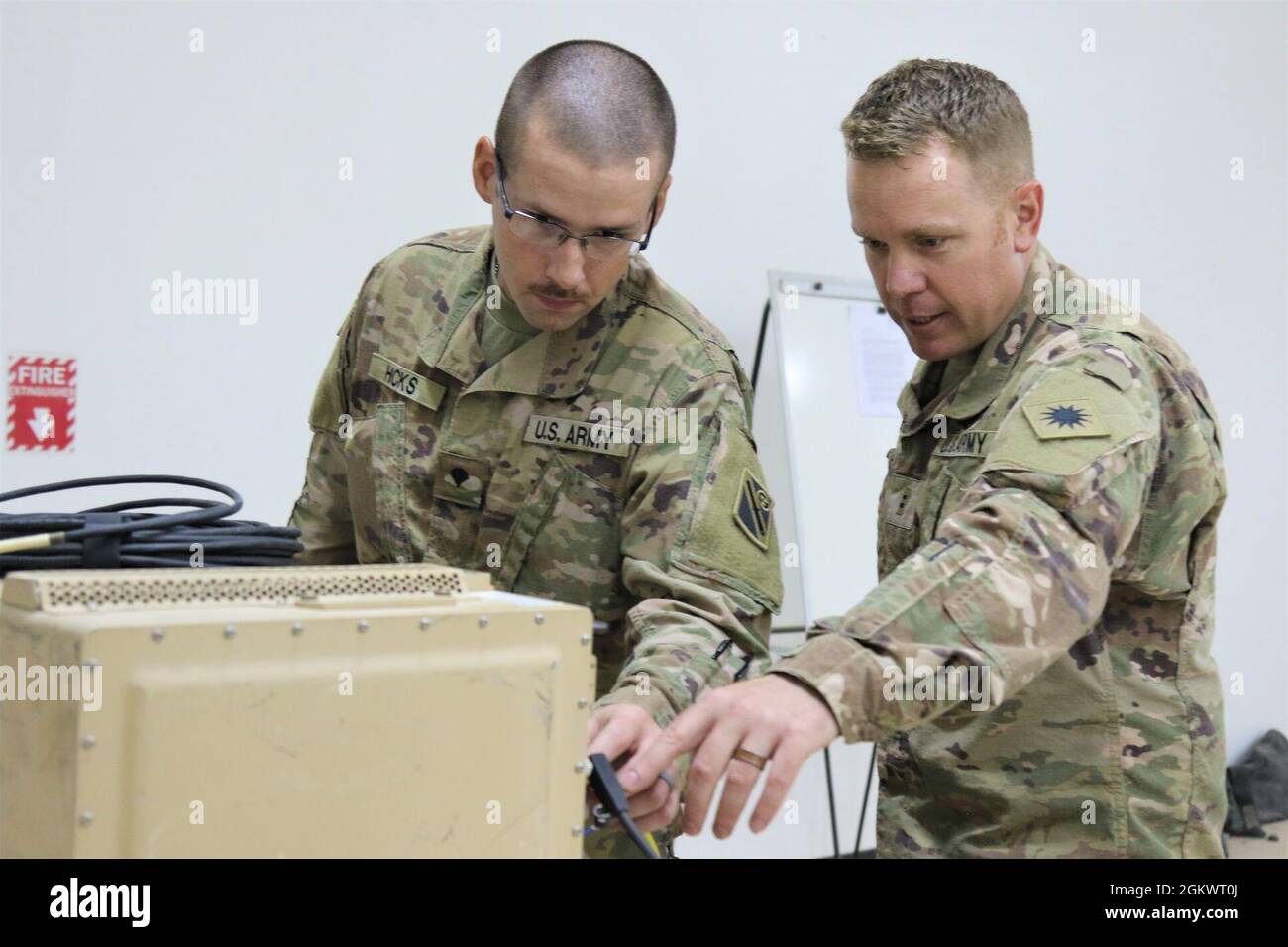 Chief Warrant Officer 2 Anthony Meneely, rechts, ein Techniker für elektronische Kriegsführung bei der Task Force Phoenix, weist SPC an. Curtis Hicks von der Tennessee National Guard, 1-181. Field Artillery Battalion, über den Betrieb eines Counter Radio-gesteuerten improvisierten Sprengstoffkriegungssystems (CREW) im Camp Buehring, Kuwait. Stockfoto