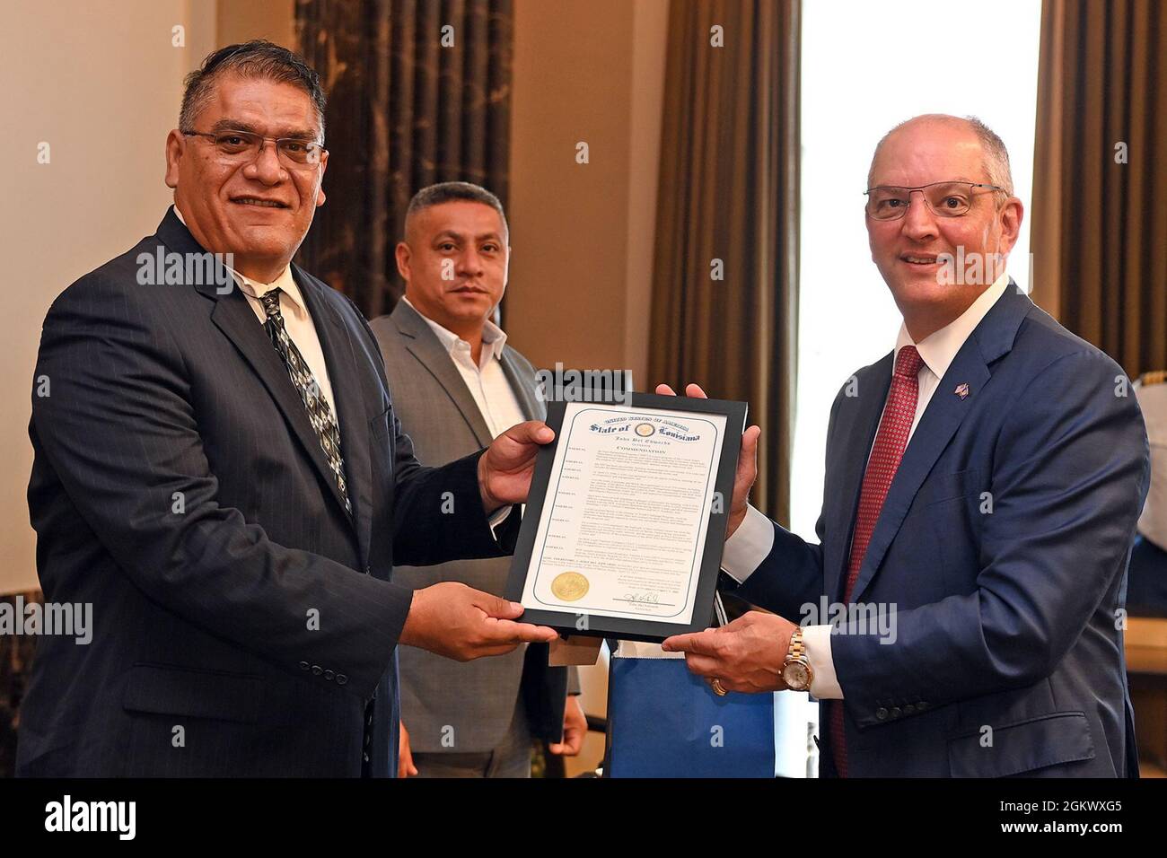 Der Gouverneur von Louisiana, John Bel Edwards, überreicht Florencio Marin, dem Verteidigungsminister von Belize, eine gerahmte Kopie seiner Anerkennung zum Gedenken an den 25. Jahrestag zwischen der Nationalgarde von Louisiana und der Belize Defence Force im Rahmen des State Partnership Program des Verteidigungsministeriums, 13. Juli 2021, Am Louisiana State Capitol in Baton Rouge, La, wurde die Partnerschaft mit Belize am 23. April 1996 mit über 270 Austauschprogrammen seit ihrer Gründung gegründet. Stockfoto