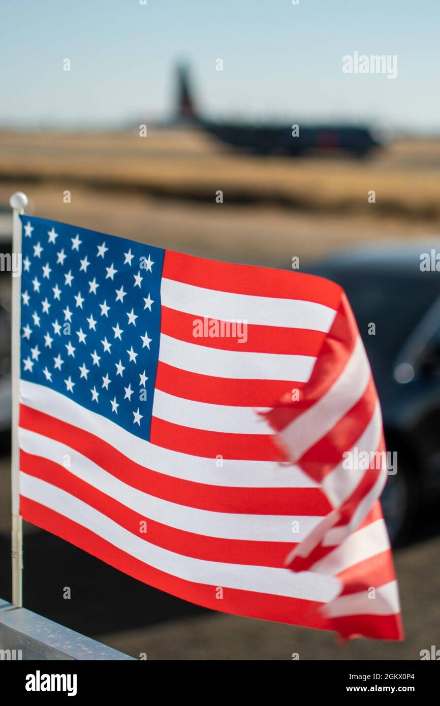 Die US-Flagge schwingt im Wind, als eine California Air National Guard C-130 zur Startbahn am 14. Juli 2021 auf der CAL FIRE Air Tanker Base, McClellan Park, Kalifornien, tastet. 130 Calif. Wurde von der National Interagency Fire Center angefordert und vom Verteidigungsminister genehmigt, bieten einzigartige Löschkapazitäten. Die MAFFS-Teams der Air Force werden von der 153. Air Expeditionary Group der First Air Force (Air Forces Northern) verwaltet. Stockfoto