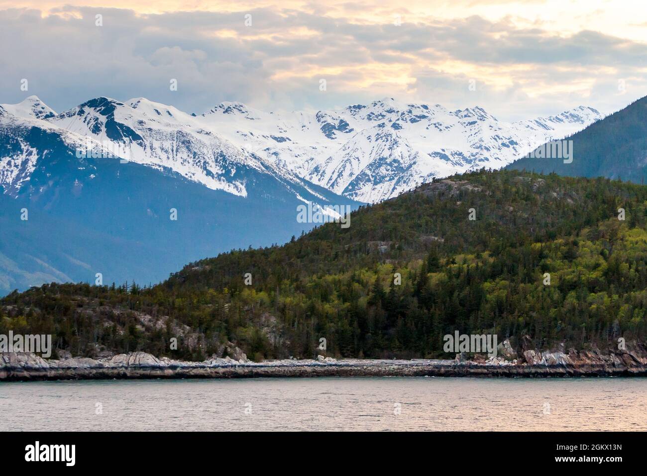 Schneebedeckte Berge und immergrüner Wald entlang des Chilkoot Inlet in der Nähe von Haines, Alaska Stockfoto