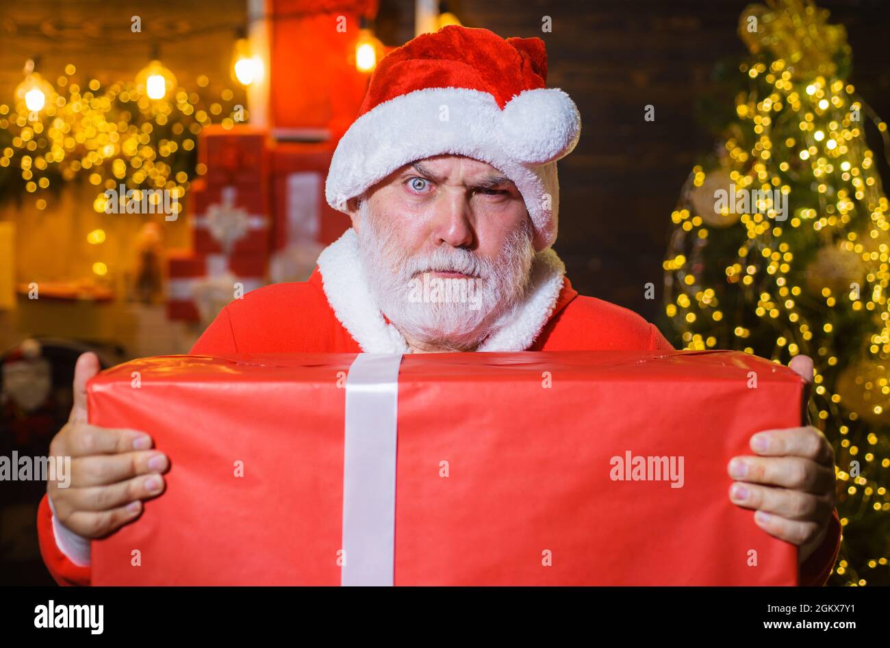 Weihnachtsmann mit Geschenkbox. Frohe Weihnachten. Frohes neues Jahr. Bärtiger Mann im Weihnachtsmann Kostüm mit Geschenk Stockfoto