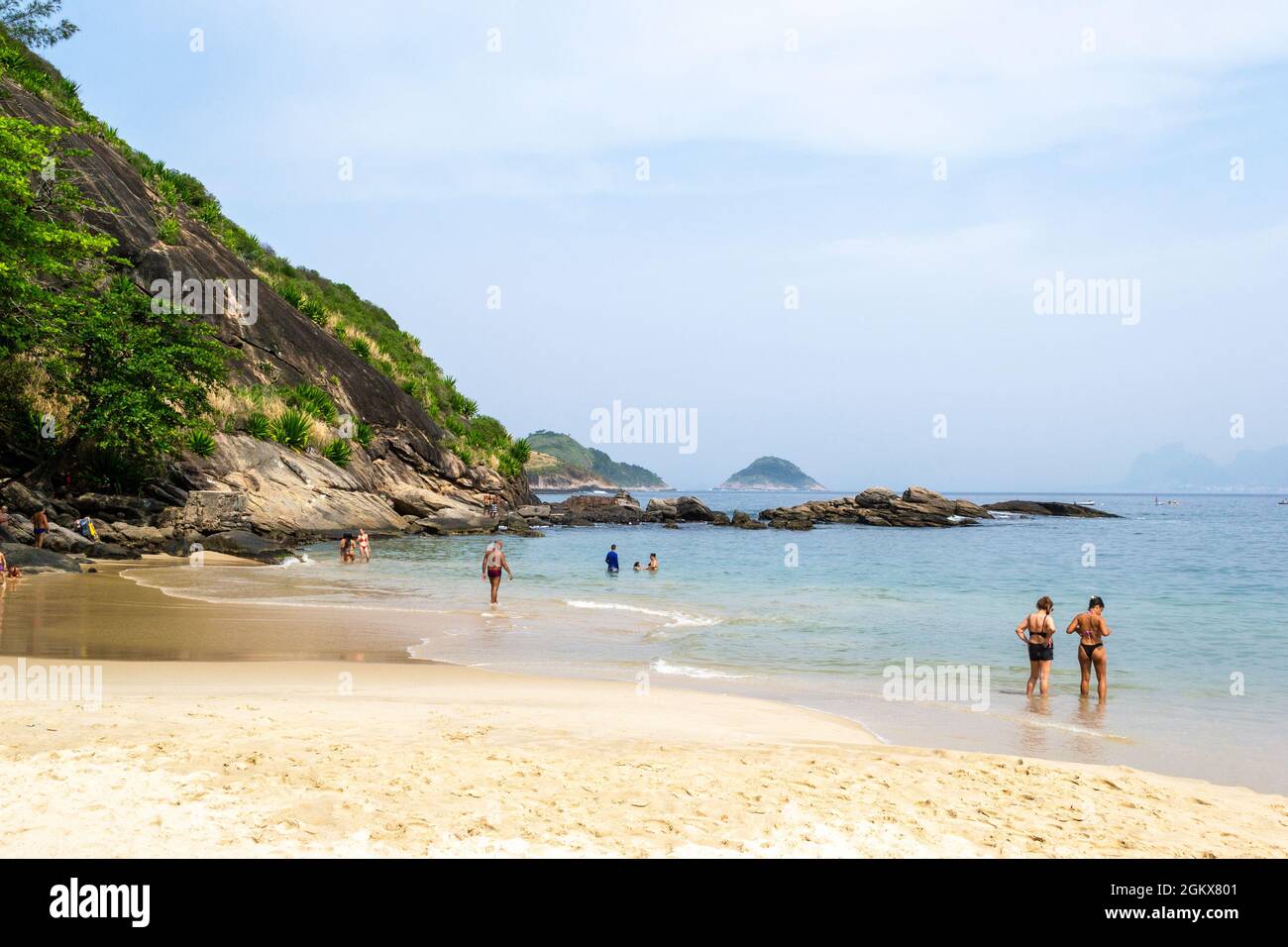 Touristen in Itaipu Beach, Rio de Janeiro, Brasilien. Schöner Berg im Kontrast zum weißen Sand. Der berühmte Ort ist ein großer touri Stockfoto