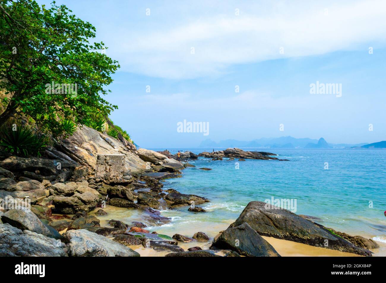 Landschaft am Rande des Wassers in Itaipu Beach, Rio de Janeiro, Brasilien. Schöner Kontrast von blauem Wasser und Felsen. Der berühmte Ort ist ein großer touris Stockfoto