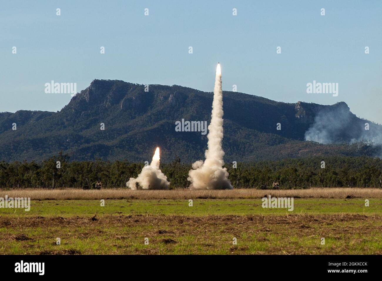 U.S. Marine Corps High Mobility Artillery Rocket Systems mit 3d Bataillon, 12th Marines, 3d Marine Division und US Army HIMARS mit Alpha Battery, 1st Bataillon, 94th Field Artillery Regiment, feuern H185 RRPR-Raketen während der Übung Talisman Sabre 21 auf Shoalwater Bay Training Area, Queensland, Australien, 17. Juli 2021. TS21, die neunte Iteration, die seit 2005 durchgeführt wurde, tritt zweijährlich in ganz Nordaustralien auf. Australische, US-amerikanische und andere multinationale Partner nutzen Talisman Sabre, um die Interoperabilität zu verbessern, indem sie in komplexen, domänenübergreifenden Geschäftsszenarien geschult werden, die sich mit dem befassen Stockfoto