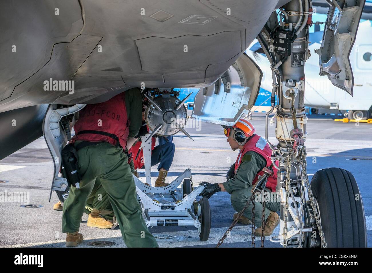 Techniker des U.S. Marine Corps Aviation Ordnance mit Marine Medium Tiltrotor Squadron 265 (verstärkt), 31. Marine Expeditionary Unit (MEU), laden während des Talisman Sabre am 18. Juli 2021 Munitionsmaterial auf einen F-35B Lightning II an Bord der USS America (LHA 6). Die Kampffähigkeiten der fünften Generation des F-35B Lightning II bieten mehr Letalität und Flexibilität im Kampf gegen Kommandeure als jede andere Flugzeugplattform. Australische und US-Streitkräfte vereinen sich alle zwei Jahre für Talisman Sabre, eine einmonatige Multi-Domain-Übung, die die Fähigkeiten von Alliierten und Partnern stärkt, um auf das gesamte Spektrum von zu reagieren Stockfoto