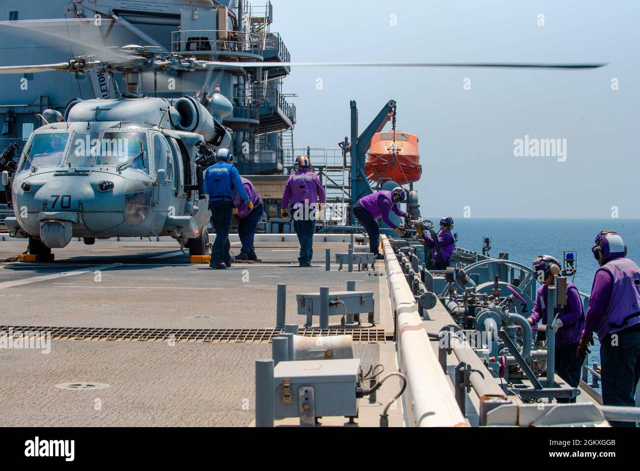 210719-N-KZ419-1210 ARABIAN GULF (19. Juli 2021) – Segler, die auf der Expeditionsbasis USS Lewis B. Puller (ESB 3) eingesetzt wurden, tanken während der Flugoperationen im Arabischen Golf am 19. Juli einen an das Helicopter Sea Combat Squadron (HSC) 26 angeschlossenen Hubschrauber MH-60S. Lewis B. Puller wird in das Einsatzgebiet der 5. US-Flotte eingesetzt, um Marineinteraktionen zu unterstützen, um die maritime Stabilität und Sicherheit in der Zentralregion zu gewährleisten und das Mittelmeer und den Pazifik durch den westlichen Indischen Ozean und drei strategische Engpässe zu verbinden. Stockfoto