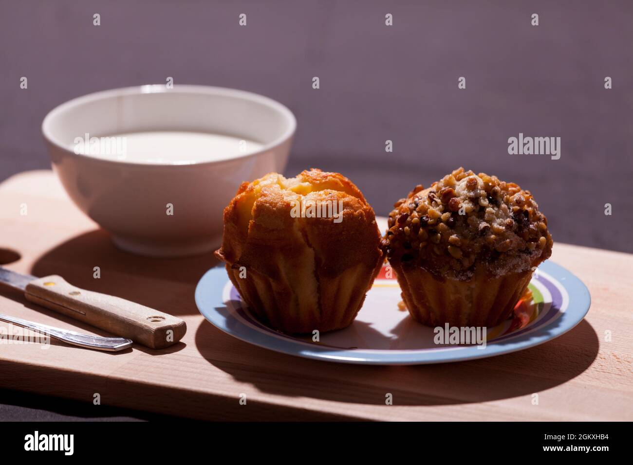 Frühstück, Snack, Milch mit handgemachten Muffins auf Holztablett mit dunklem Hintergrund. Stockfoto