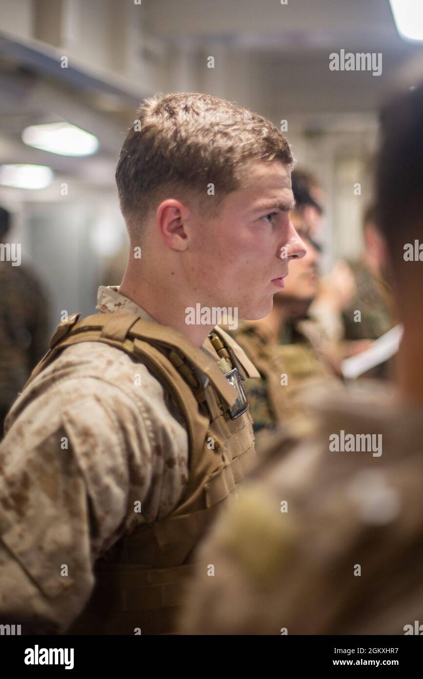 Eine US-Marine mit der 31. Marine Expeditionary Unit (MEU) hört sich während eines Kurses des Marine Corps Martial Arts Program (MCMAP) an Bord des amphibischen Angriffsschiffs USS America (LHA 6) in der Korallenmeer, 20. Juli 2021, Anweisungen an. Das MCMAP-Training vermittelt Marineinfanteristen Hand-in-Hand-Kampftechniken, um sich in Kampfsituationen gegen den Feind zu verteidigen oder ihn zu entmündigen. Die 31. MEU ist an Bord von Schiffen der America Expeditionary Strike Group im 7. Einsatzgebiet der Flotte tätig, um die Interoperabilität mit Verbündeten und Partnern zu verbessern und als einsatzbereite Einsatztruppe für Frieden und Stabilität in der Indo-P zu dienen Stockfoto