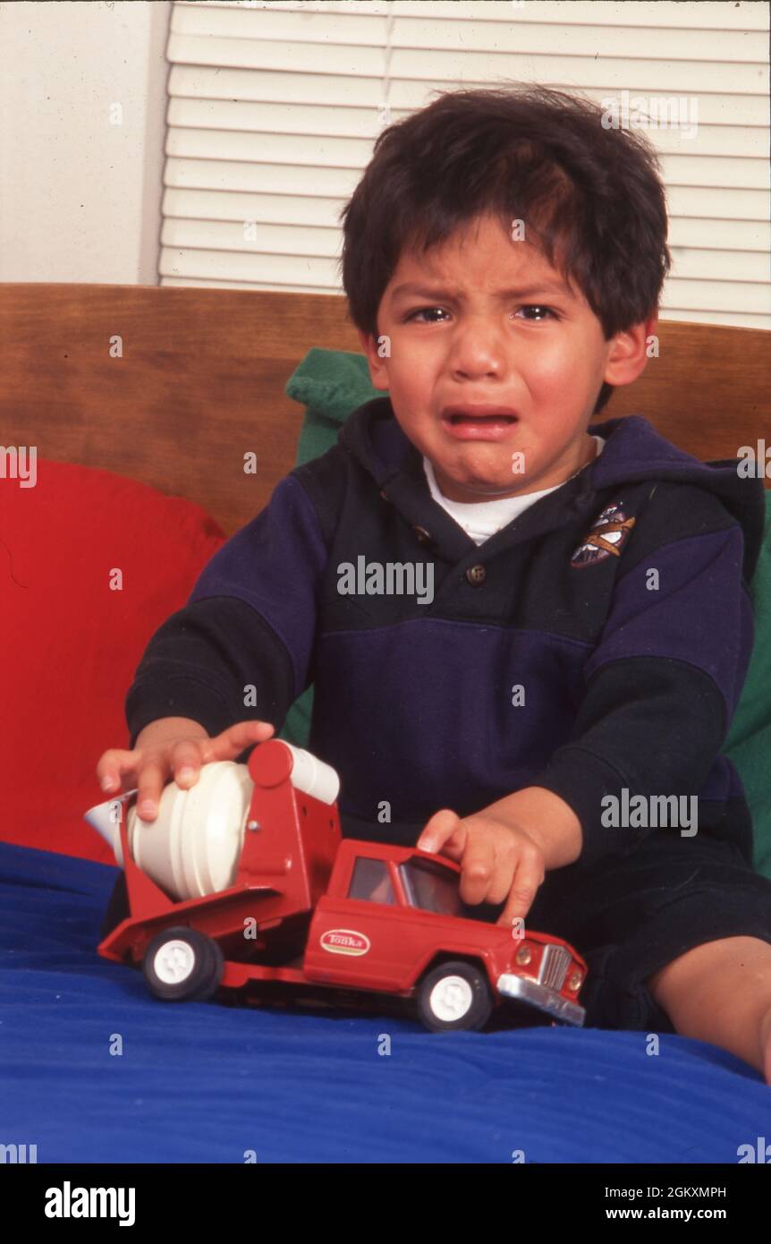 ©1997 Kinder: Guatemaltekischer Adoptivjunge, 3 Jahre alt, von amerikanischer Familie adoptiert, der wegen eines Spielzeugs weint. HERR EU-005 Stockfoto