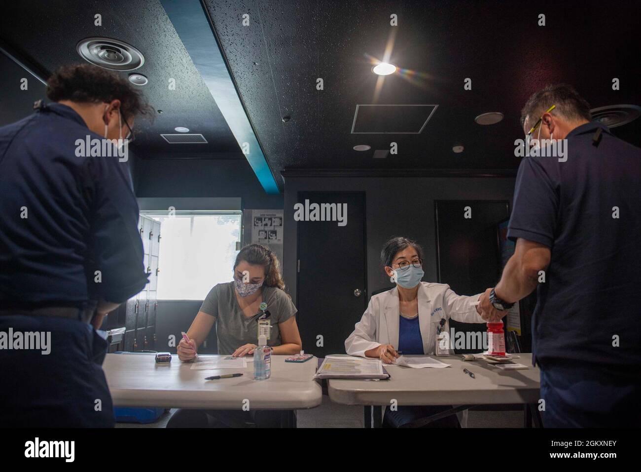 Taylor McNabb und Noriko King, eingetragene Krankenschwestern, die mit der US Naval Hospital Yokosuka Branch Health Clinic Sasebo zusammenarbeiten, bereiten den japanischen Master Labor Contract (MLC), Indirect Hire Agreement (IHA) vor, Und Mariner’s Contract (MC), die zweite Dosis des Impfstoffs Moderna COVID-19 im Commander, Fleet Activities Sasebo’s (CFAS) Showboat Theatre, 21. Juli 2021 zu erhalten. Nach Genehmigung der Regierung von Japan begann CFAS im Juni 23 mit der Verabreichung von Impfstoffen an MLC-, IHA- und MC-Mitarbeiter, die auf der Basis beschäftigt waren. Stockfoto