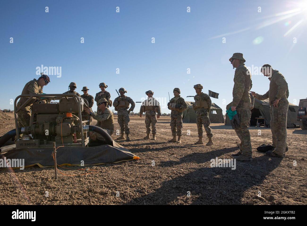 US Marine Corps Bulk Fuel Specialists mit Combat Logistics Regiment 3, 3d Marine Logistics Group, Und Mineralölbetreiber der Australischen Armee mit dem 10. Force Support Bataillon versammeln sich um die V-35 Kraftstoffpumpe, um ihre Fähigkeiten und Komponenten während der Übung Talisman Sabre 21 auf dem Hughenden Airfield in Queensland, Australien, am 21. Juli 2021 zu erlernen. Australische und US-Streitkräfte vereinen sich zweijährlich für Talisman Sabre, eine einmonatige Multi-Domain-Übung, die die Fähigkeiten von Alliierten und Partnern stärkt, um auf die gesamte Bandbreite der Sicherheitsbedenken im Indo-Pazifik-Raum zu reagieren. Stockfoto