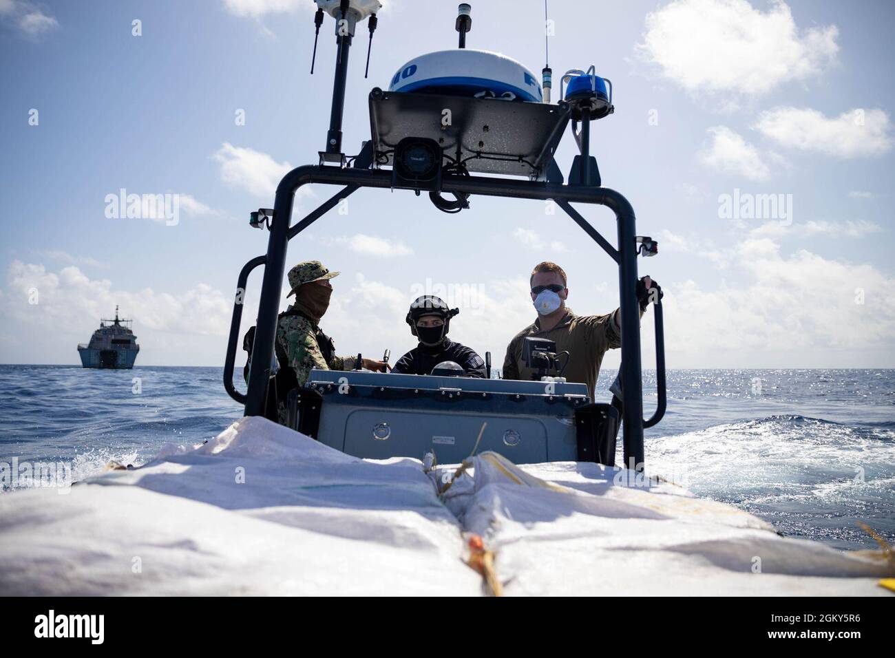 210725-N-RL695-1243 KARIBISCHES MEER - (25. Juli 2021) -- Küstenwache, die dem Tactical Law Enforcement Team 105 zugewiesen wurde, und Seeleute, die dem Freedom-Variant Littoral Combat Ship USS Sioux City (LCS 11) zugewiesen wurden, überweisen mutmaßlichen Schmuggelware an den USCGC Forward (CG 911), 25. Juli 2021. Sioux City wird in den Einsatzbereich der 4. US-Flotte entsandt, um die Mission der Joint Interagency Task Force South zu unterstützen, die auch Einsätze zur Bekämpfung des illegalen Drogenhandels in der Karibik und im Ostpazifik umfasst. Stockfoto