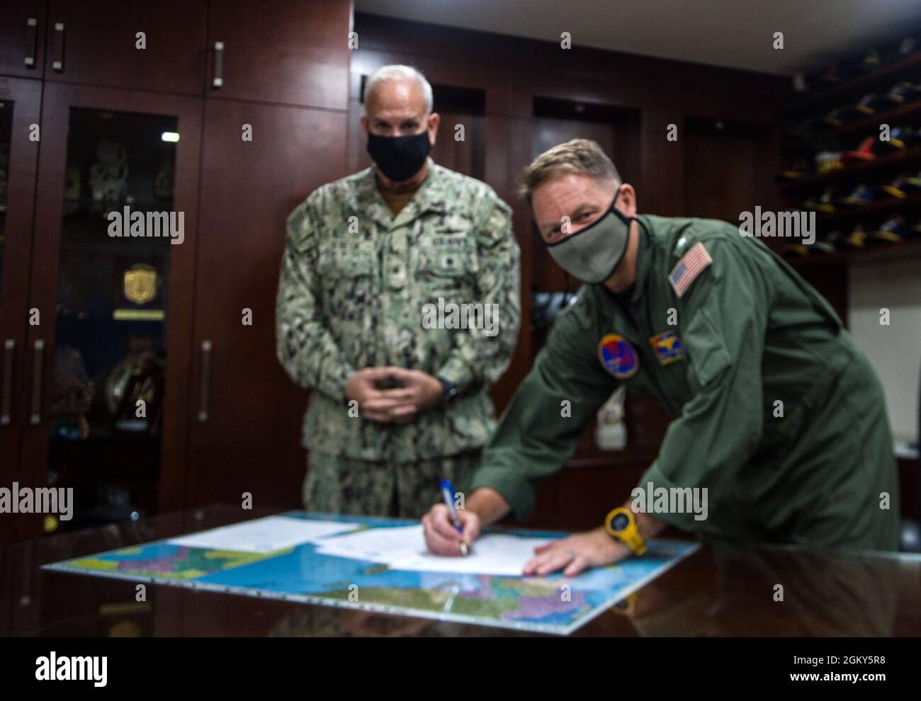 SINGAPUR (26. Juli 2021) ADM hinten. Joey Tynch, der scheidende Kommandant der Logistics Group Western Pacific/Task Force 73 (COMLOG WESTPAC/CTF 73), rechts und hinten ADM. Philip Sobeck, der ankommende Kommandant, verließ die Seite und unterschrieb Dokumente, die ihren Befehlswechsel am 26. Juli abschließen. COMLOG WESTPAC/CTF 73 ist der Anbieter von kampfbereiter Logistik der 7. Flotte, die Schiffe in Staatsbesitz und unter Vertrag nimmt, um Einheiten in der gesamten Flotte zu betankt, zu füttern und im Kampf zu halten. Stockfoto