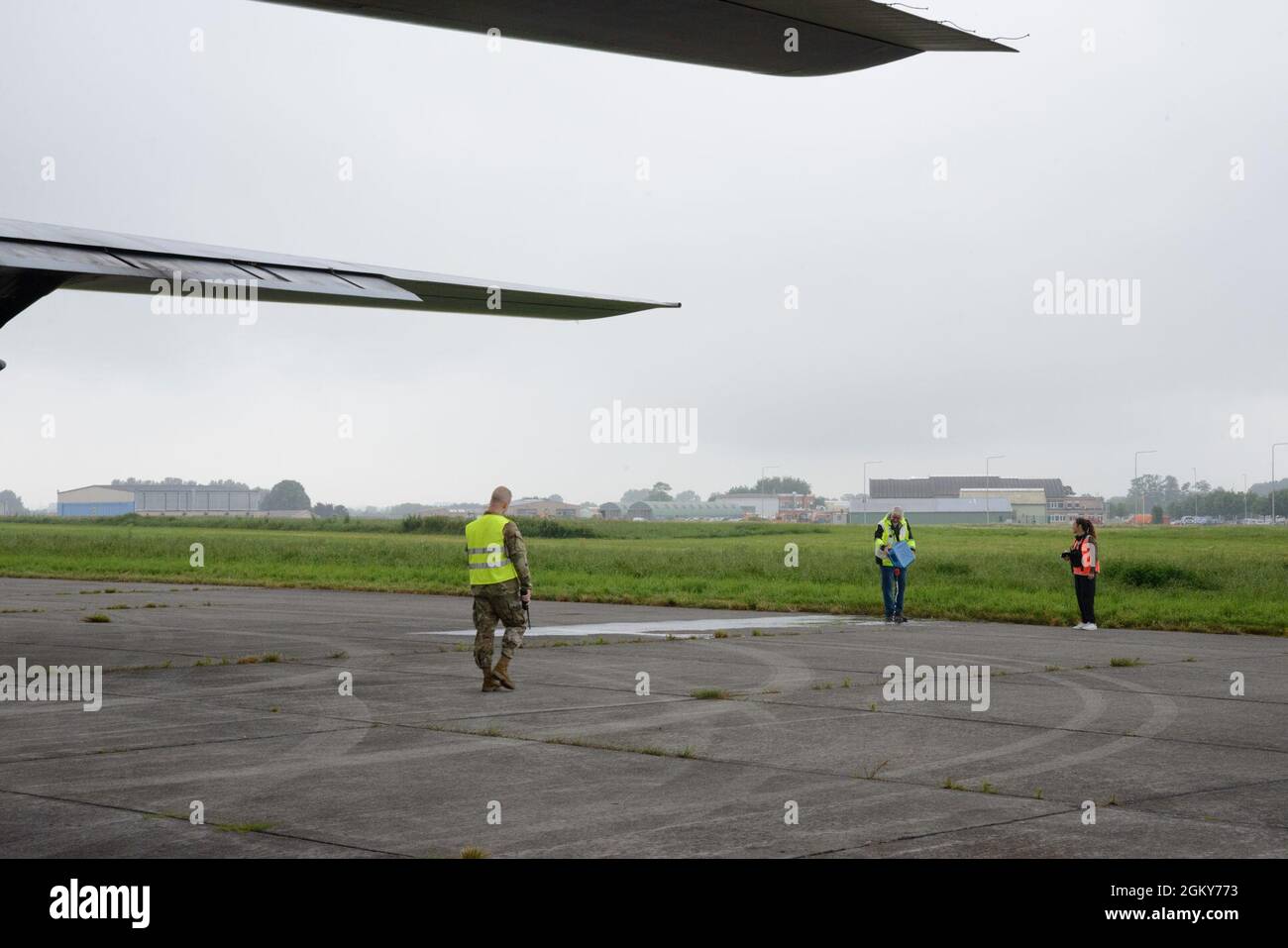 John Hopper, US Army Garrison Benelux Emergency Manager, gießt Wasser, um vor einer Flugzeugabsturzübung ein Kraftstoffleck zu simulieren, auf dem Luftwaffenstützpunkt Chièvres, Belgien, 26. Juli 2021. Sentinel Shield 21 war die integrierte Schutzübung der US Army Garrison Benelux und testte die Interoperabilität mit den Flugzeugen des 424. Air Base Squadron nach einem simulierten Flugzeugabsturz. Stockfoto