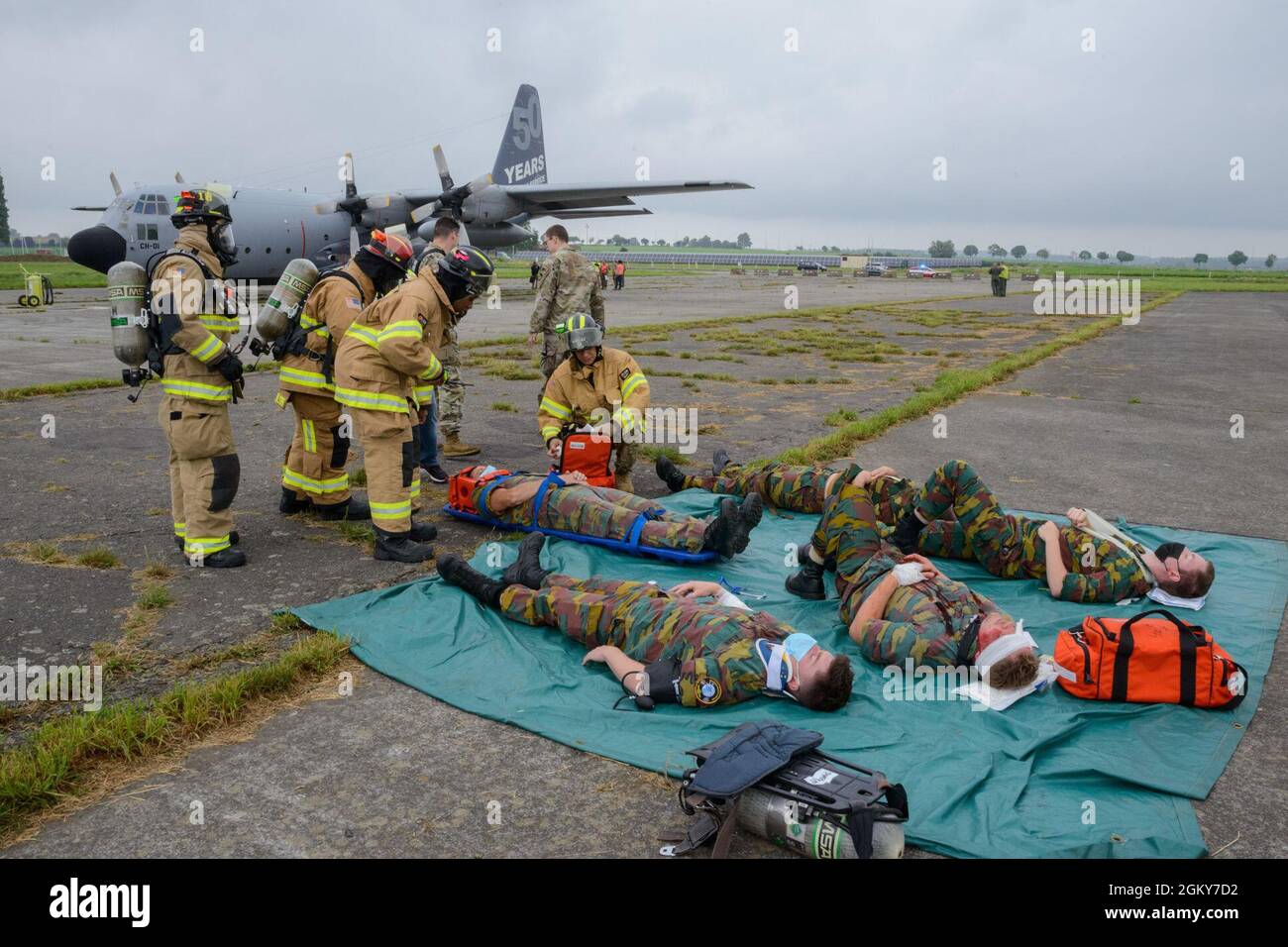 Die Feuerwehrleute der US-Luftwaffe mit dem 424. Flugplatz-Geschwader leisten auf dem Luftwaffenstützpunkt Chièvres, Belgien, am 26. Juli 2021 erste Hilfe für Verletzte während einer simulierten Flugzeugabsturzübung. Sentinel Shield 21 war die integrierte Schutzübung der US Army Garrison Benelux und testte die Interoperabilität mit den Flugzeugen des 424. Air Base Squadron nach einem simulierten Flugzeugabsturz. Stockfoto