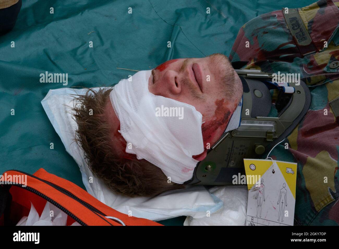 Ein Mitglied der belgischen Streitkräfte, stationiert auf dem Luftwaffenstützpunkt Melsbroek, spielt einen Unfall während einer simulierten Flugzeugabsturzübung auf dem Luftwaffenstützpunkt Chièvres, Belgien, am 26. Juli 2021. Sentinel Shield 21 war die integrierte Schutzübung der US Army Garrison Benelux und testte die Interoperabilität mit den Flugzeugen des 424. Air Base Squadron nach einem simulierten Flugzeugabsturz. Stockfoto