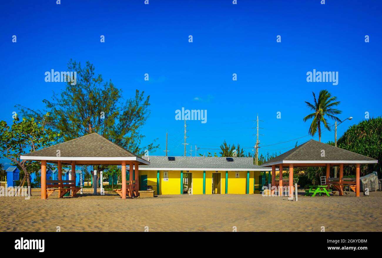 Farbenfrohes öffentliches Toilettengebäude und Holzhütten am Seven Mile Beach am Karibischen Meer, Grand Cayman Stockfoto