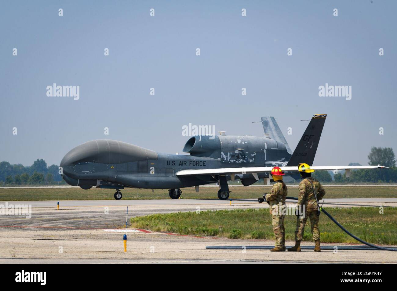 Die Feuerwehr der Grand Forks Air Force Base erwartet den endgültigen Anflug des EQ-4 Block-20 Global Hawk, um ihn feierlich mit einem Wasserbogen auf der Grand Forks Air Force Base, N.D., am 29. Juli 2021 zu begrüßen. Der Wasserbogen ist eine traditionelle Absendung für Flugzeuge, die nach ihrem letzten Flug ausgemustert werden. Stockfoto