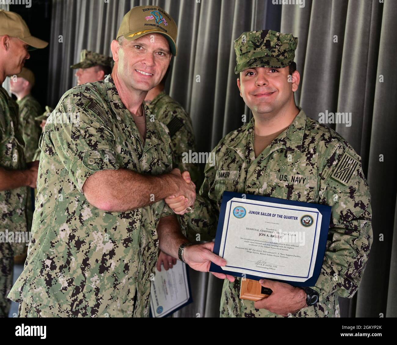 DIEGO GARCIA, Britisches Territorium im Indischen Ozean (30. Juli 2021) – Hospital Corpsman 2. Klasse Jon A. Baker, der der Navy Medicine Readiness and Training Unit Diego Garcia zugewiesen wurde, erhält ein Junior Sailor of the Quarter Zertifikat und eine Plakette von Kapitän Richard D. Payne, dem Kommandanten von NSF Diego Garcia, Während einer Preisverleihung am 30. Juli 2021. NSF Diego Garcia bietet Logistik-, Service-, Freizeit- und administrative Unterstützung für US- und alliierte Truppen, die im Indischen Ozean und im Arabischen Golf eingesetzt werden. Stockfoto