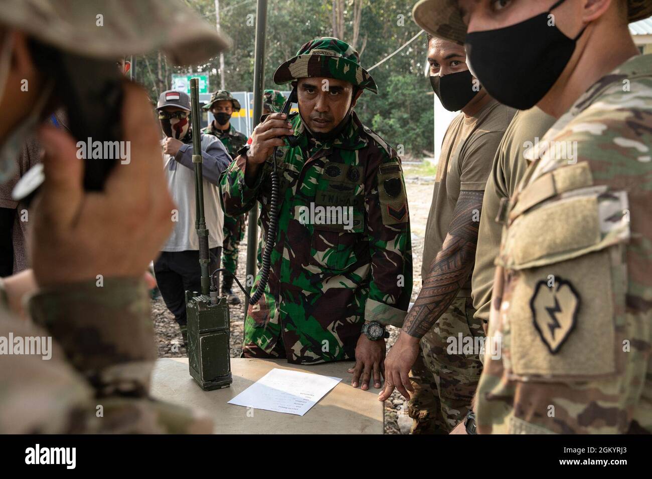 Soldaten der US-Armee mit Task Force Warrior und einem ihrer Gegenstücke der Tentara Nacional Indonesia (Indonesische Streitkräfte) üben am 1. August 2021 im Baturaja Training Area, Indonesien, die Umsetzung von Radio-Etikette-Taktiken der US-Armee. Garuda Shield ist eine gemeinsame Übung mit dem Ziel, die Dschungelkriegfähigkeit sowohl der US-Armee als auch der indonesischen Armee zu verbessern und zu bereichern. Stockfoto