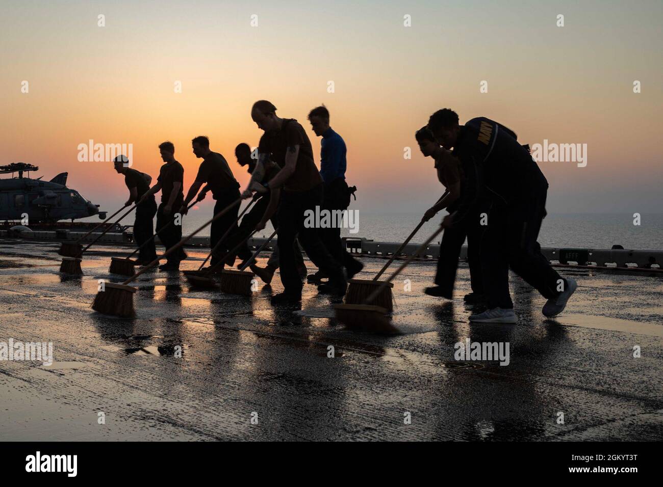 210731-N-LN075-2017 ARABIAN GULF (31. Juli 2021) Seeleute, die dem amphibischen Sturmschiff USS Iwo Jima (LHD 7) der Wasp-Klasse zugewiesen wurden, scheuern das Flugdeck des Schiffes, 31. Juli. Iwo Jima wird im Einsatzgebiet der 5. US-Flotte eingesetzt, um Marinestützpunkte zu unterstützen, um die maritime Stabilität und Sicherheit in der Zentralregion zu gewährleisten und das Mittelmeer und den Pazifik durch den westlichen Indischen Ozean und drei strategische Engpässe zu verbinden. Stockfoto