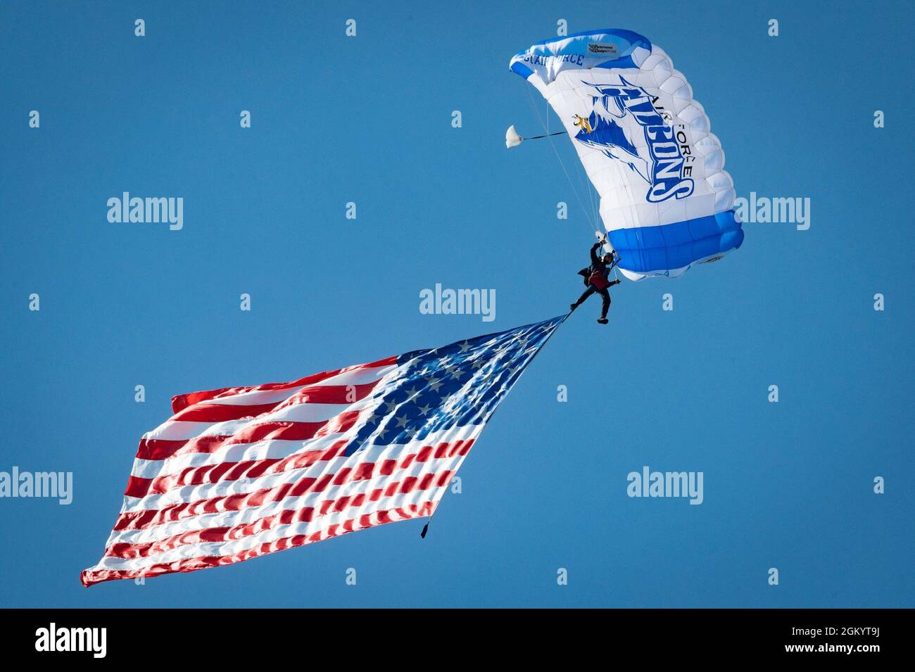 Während der Arctic Lightning Airshow 2021 auf der Eielson Air Force Base, Alaska, am 31. Juli 2021, gleitet ein Parajumper der US Air Force Academy Wings of Blue an der amerikanischen Flagge. Das Team eröffnete die Air Show, indem es während des Singens der Nationalhymne die amerikanische Flagge flog. Stockfoto