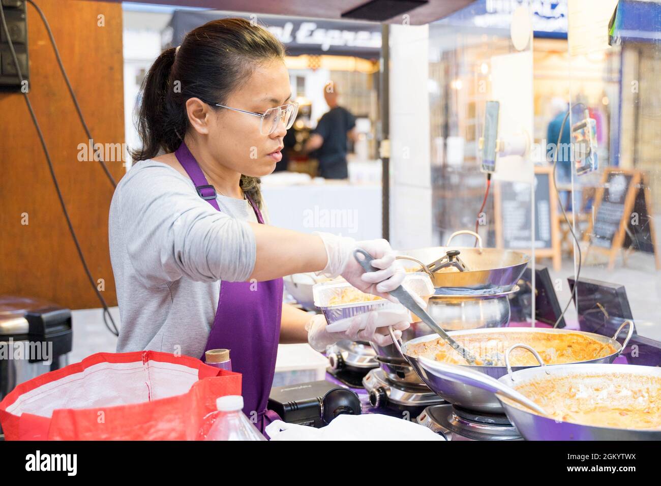 Thailänderin serviert Thai Street Food auf dem Londoner Greenwich Market in England Stockfoto