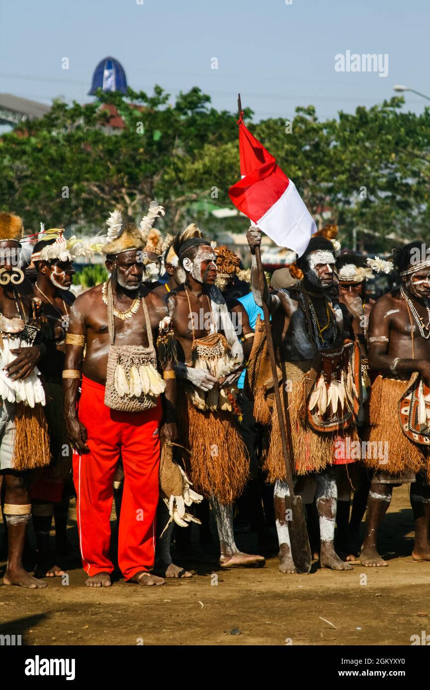 Asmat-Männer, die nach dem Asmat-Festival in Ancol, Jakarta, in der Schlange mit roten und weißen Fahnen stehen. Stockfoto