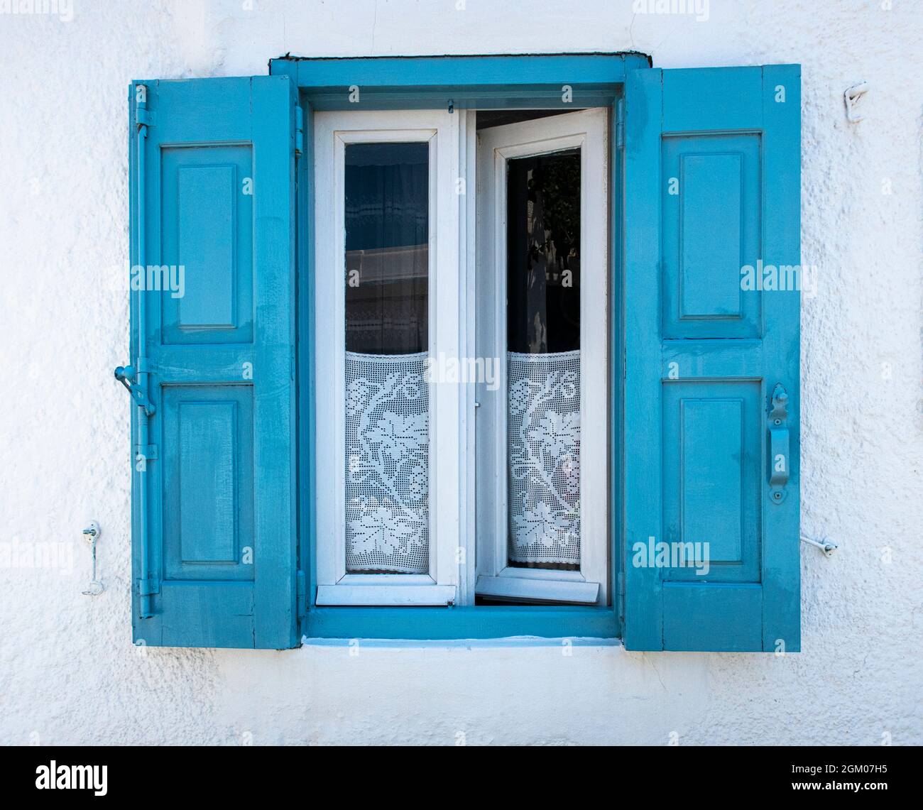 Klassische blaue Fensterläden auf einem weißen Haus auf einer griechischen Insel Stockfoto