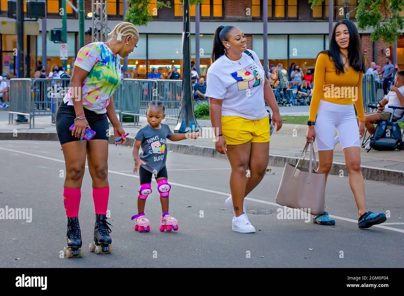 Ein Mädchen lernt Rollerskaten während Roll Mobile, 10. September 2021, in Mobile, Alabama. Die Skate Night findet monatlich am zweiten Freitag der Stadt statt. Stockfoto