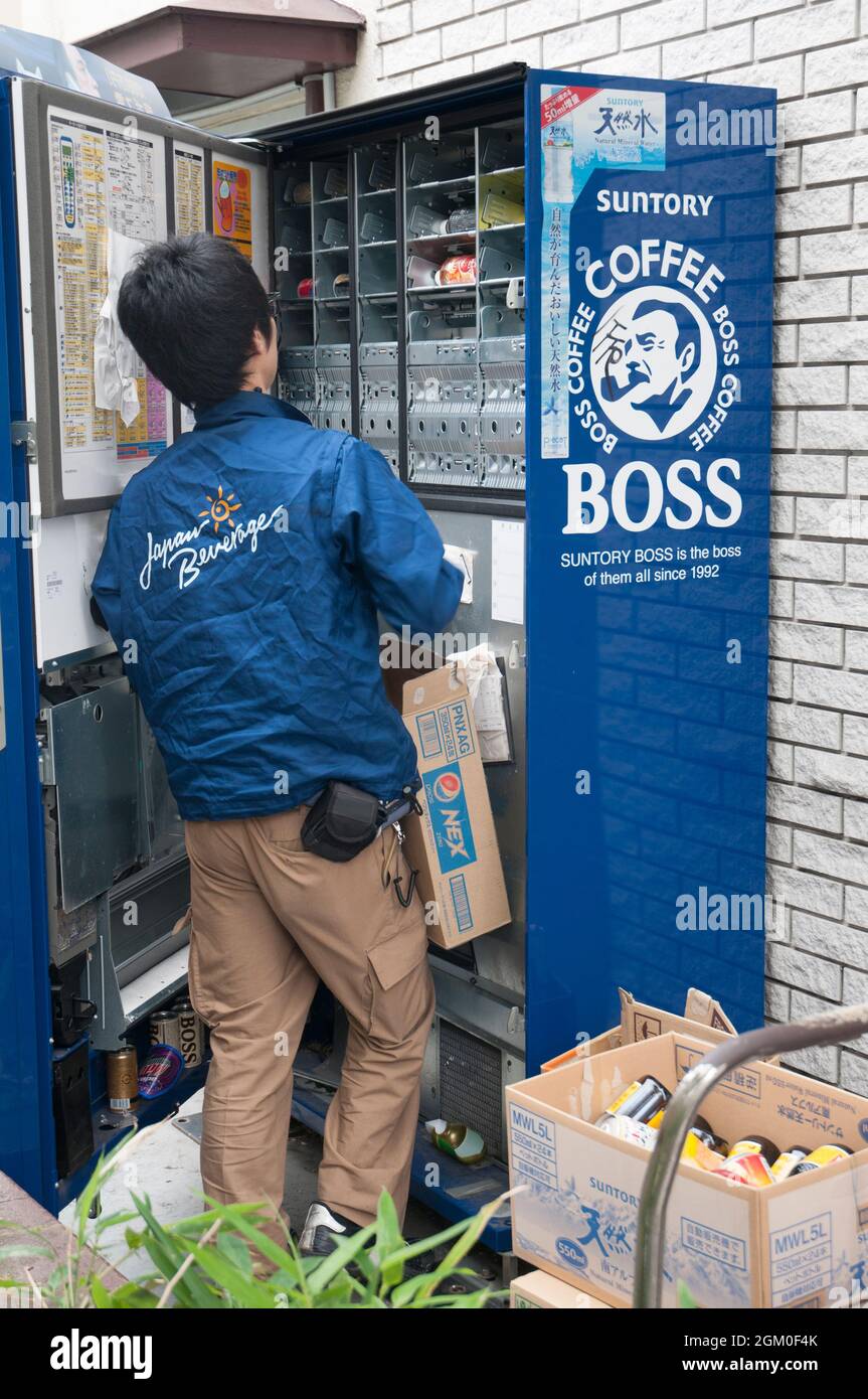 Arbeiter lädt Waren in einen Automaten in Tokio, Japan Stockfoto