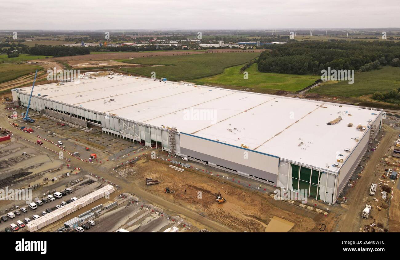 Dummerstorf, Deutschland. September 2021. Im „Baltic Sea Industrial Park“ der Gemeinde Dummerstorf wird derzeit ein großes Logistikzentrum mit mehr als 1,000 Mitarbeitern für den weltweit größten Online-Händler Amazon gebaut, dessen Fertigstellung für Sommer 2022 geplant ist. (Luftaufnahme mit Drohne) für die Gemeinde mit 7500 Einwohnern in der Nähe von Rostock und für die gesamte Region ist das Projekt aus Sicht von Bürgermeister Wiechmann ein Gewinn. Quelle: Bernd Wüstneck/dpa-Zentralbild/dpa/Alamy Live News Stockfoto